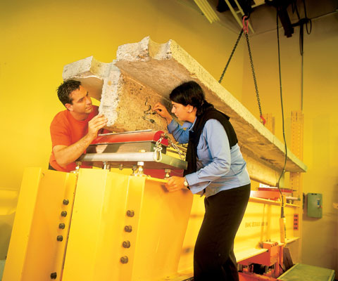 Deux chercheurs travaillent sur un bloc de ciment dans un laboratoire.