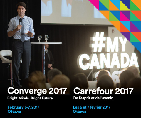 Prime Minister Justin Trudeau speaking to students at a Q&A session with #MyCanada sign lighted up in background - Converge 2017.