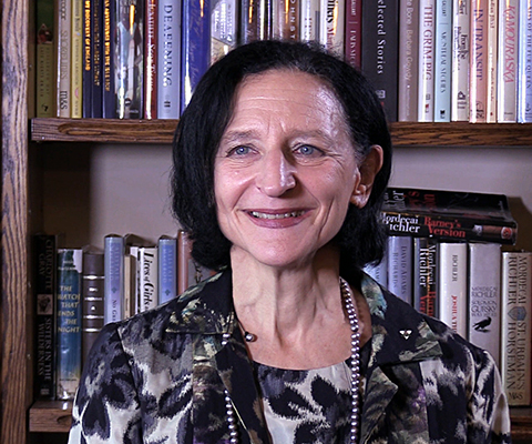 Sara Diamond, president of OCAD University, sitting in front of a bookshelf.