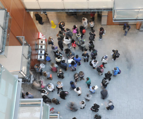 An overview of students gathering in the lobby of a university building.