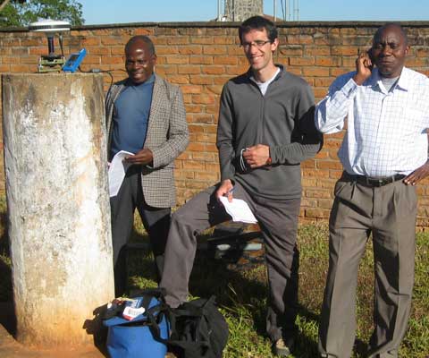 Un chercheur blanc avec ces deux collègues africains prennent des notes et font de la recherche à l
