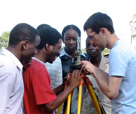 A Canadian student with colleagues in Africa looking at a tripod.