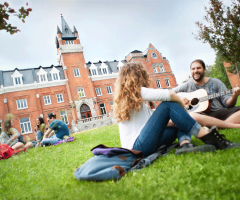 Students sitting in the garden of Bishops University with Music instrument 