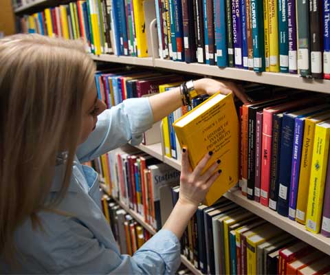 A female pick a book in library