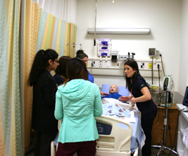 Female students standing near the patient bed