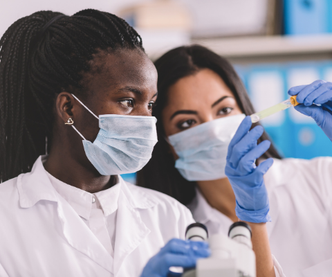Two women with masks and gloves working in a lab