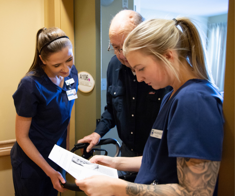 Two nursing students talking with a senior citizen / Deux étudiants en soins infirmiers discutent avec une personne âgée