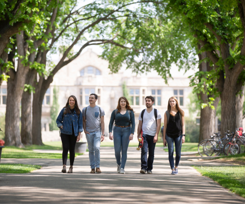 Five students walking away from a campus building / Cinq étudiants s'éloignant d'un bâtiment du campus