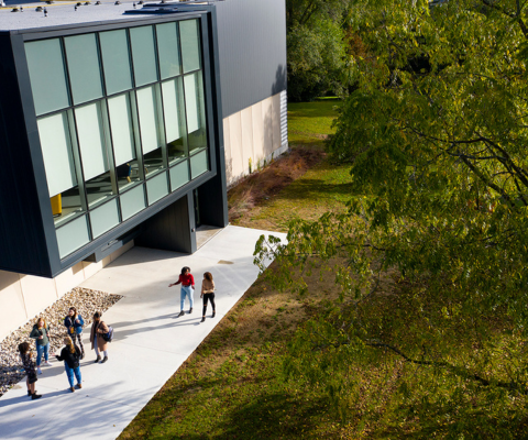Aerial image of a campus building with students outside
