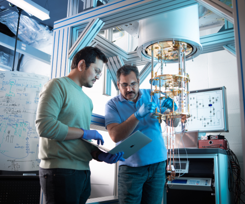 Two men working in a lab with a computer and machinery / Deux hommes travaillant dans un laboratoire avec un ordinateur et des machines
