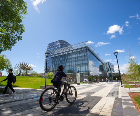 Student biking through campus