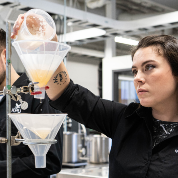 Students pouring beer into funnels in lab