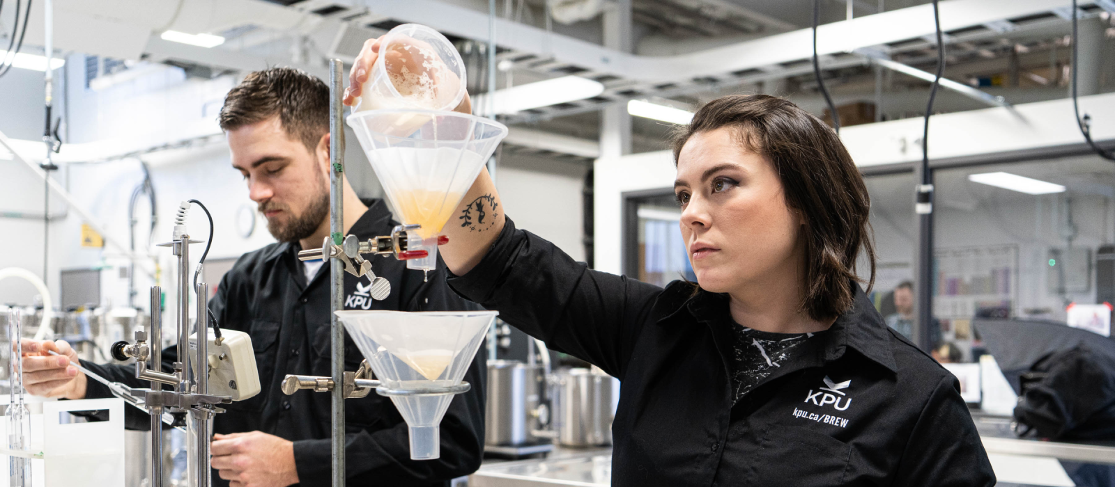 Students pouring beer into funnels in lab