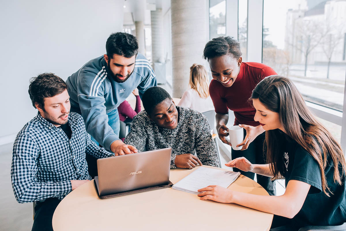 A diverse group of students working around a table.