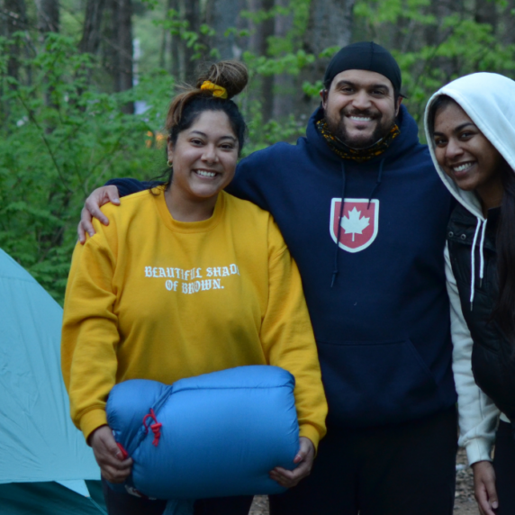 3 people posing and smiling camping in forest