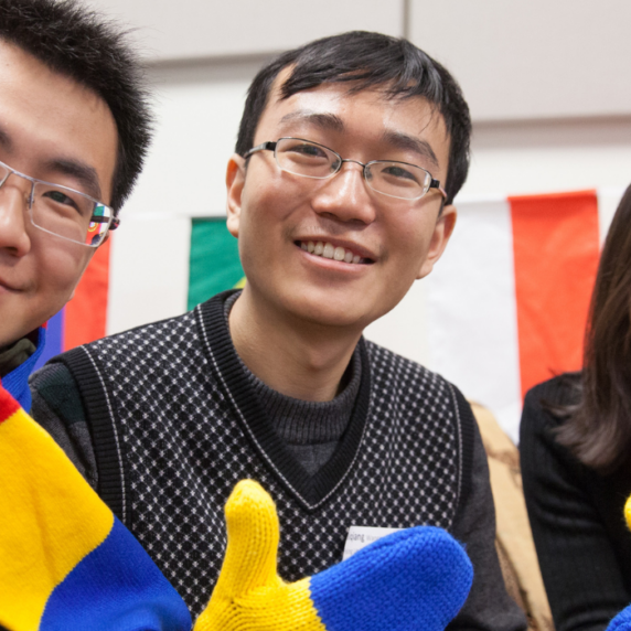 Three international students wearing winter gear in school colours