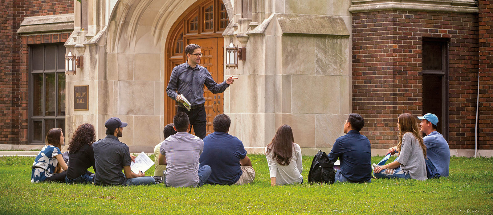 Teacher giving lecture to students on university Garden