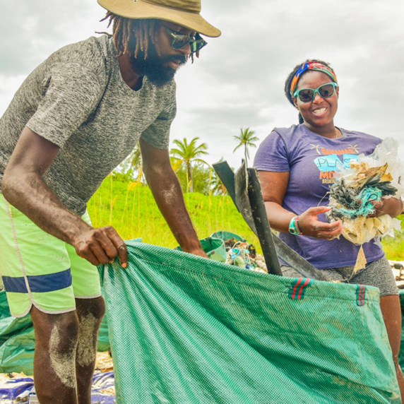 Kristal Ambrose picking up garbage along the beach with other people