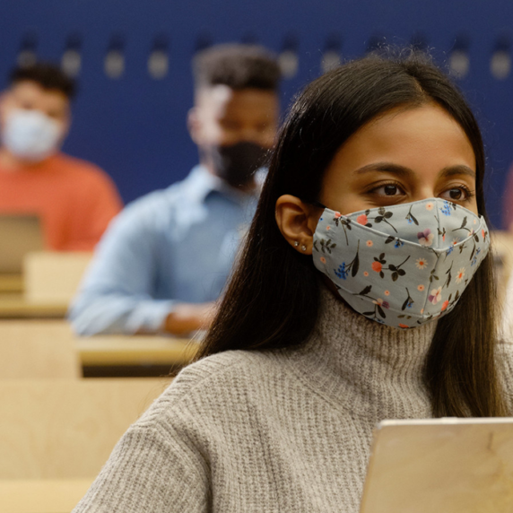 Students Sitting in class room wearing face mask