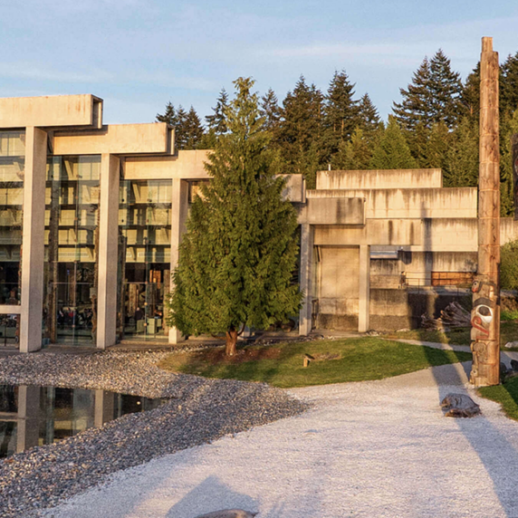 Modern building with totem poles around it