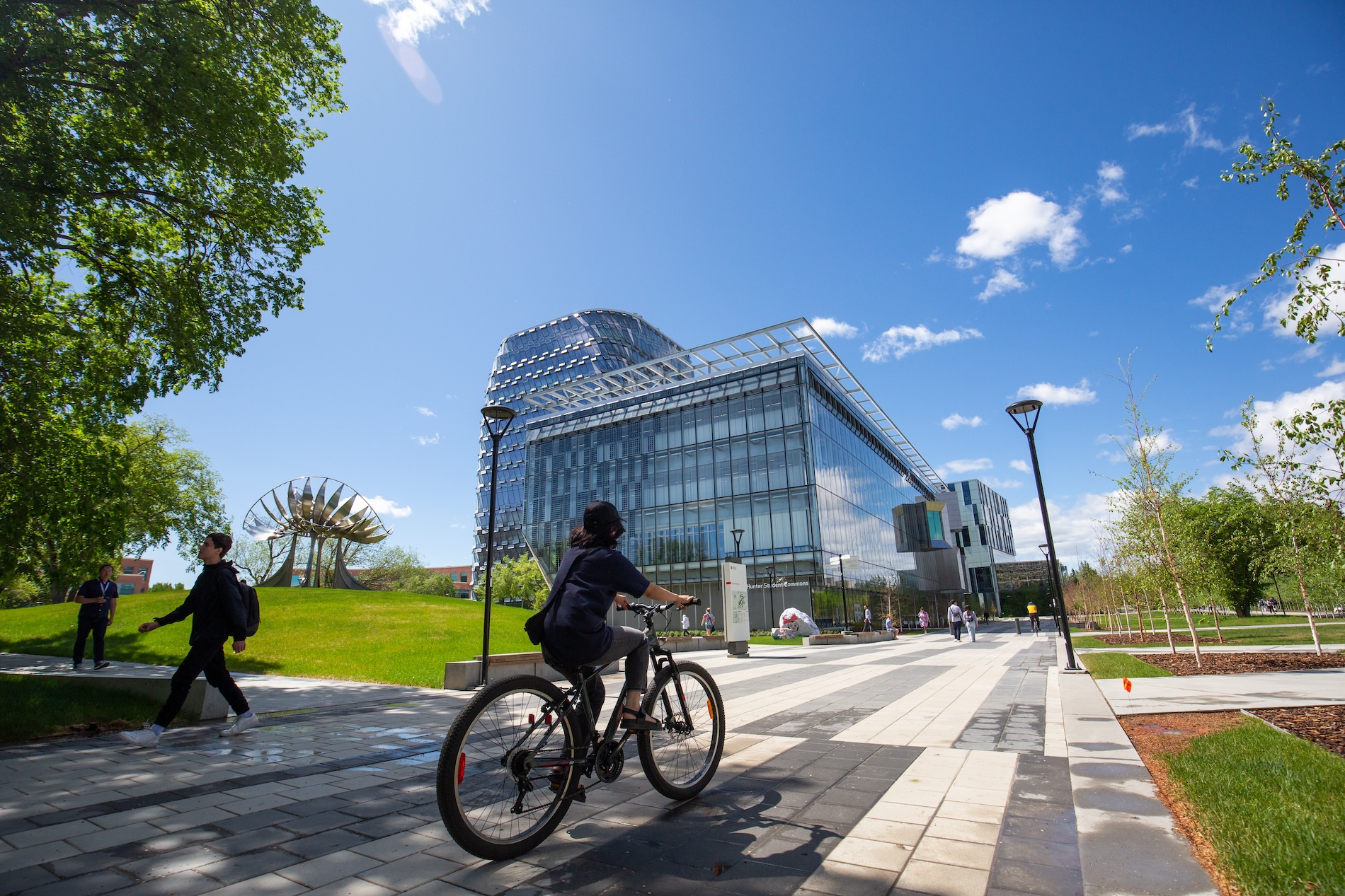 Student riding a bike outside of the University of Calgary campus