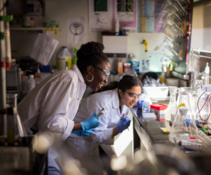 2 people in lab coats working in lab