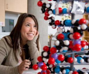 Indigenous student looking at a ball and spoke model in a lab.