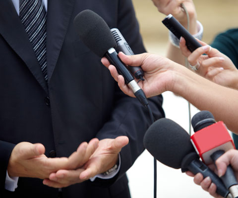 Hands holding microphones and recorders interviewing someone