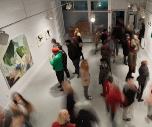 Students standing in a hallway while four students observe a painting on the wall