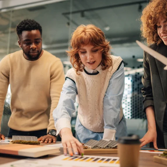 People are looking at plans in a meeting room