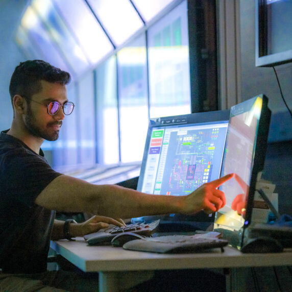 A student in a computer lab working on a double-monitored computer.
