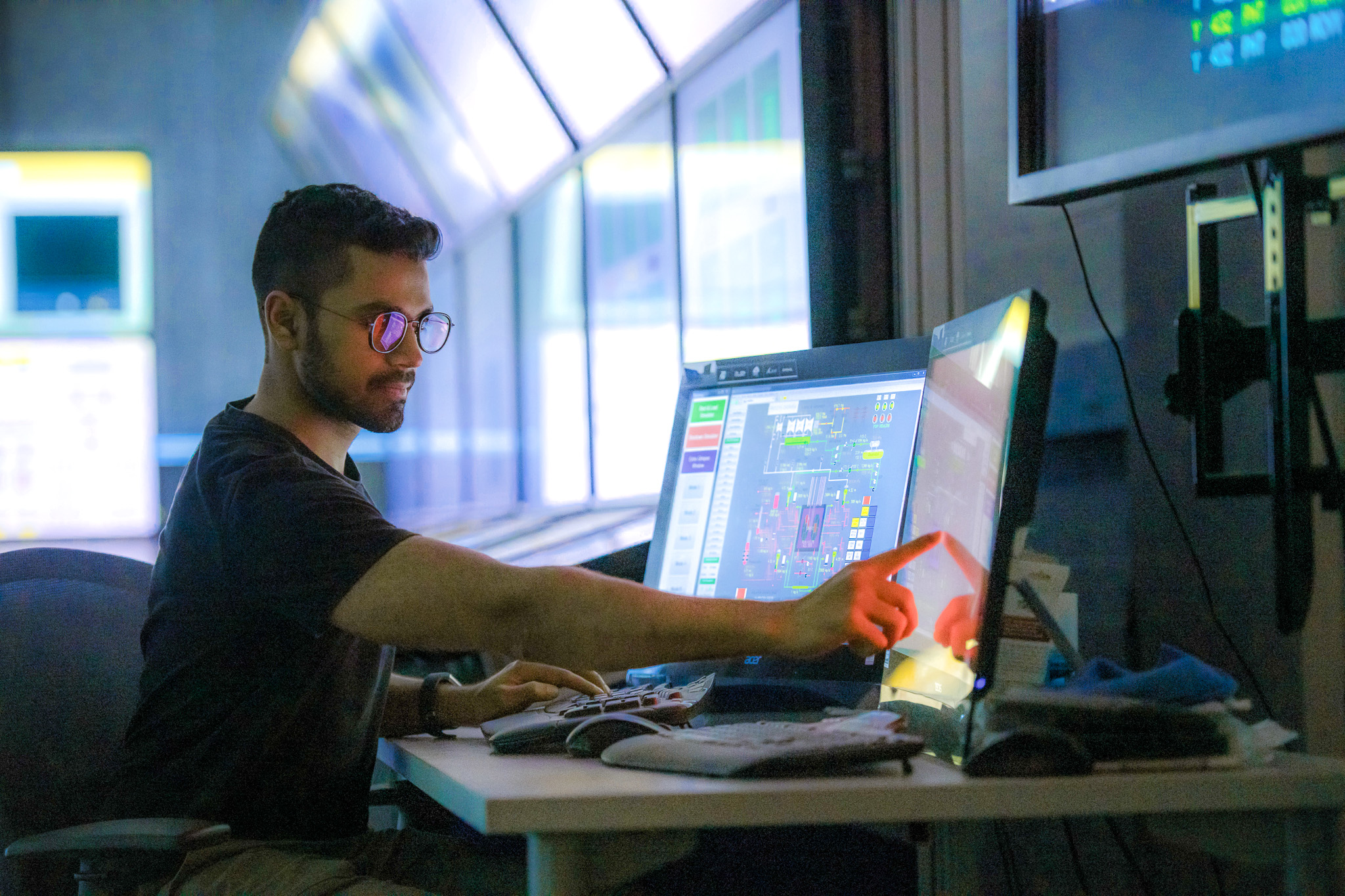 A student in a computer lab working on a double-monitored computer.